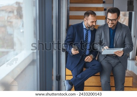 Logo, collaboration and businessman talking to an employee about a development project. Shot of two businessmen walking and talking together in the lobby of an office building
