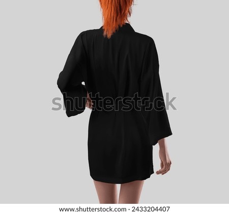 Template of black silk robe on sporty girl with bright hair, back view, kimono with belt, place for design, pattern, branding. Mockup of female home apparel above the knees, isolated on background. Royalty-Free Stock Photo #2433204407