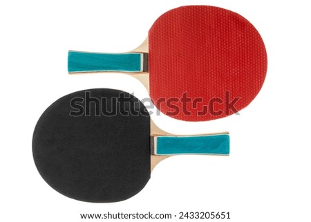 Sports equipment for table tennis in a minimalist style. Red and black table tennis rackets are highlighted on a white background with a cropped outline. Flat surface, top view. Royalty-Free Stock Photo #2433205651
