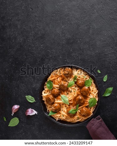 This is a picture of a delicious serving of spaghetti and meatballs garnished with fresh basil leaves.