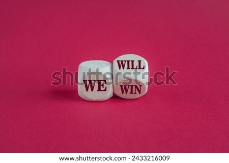 Turned a cube and changes red words we will to we win. Beautiful pink background, copy space. Business, motivational and we will win concept. Royalty-Free Stock Photo #2433216009