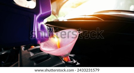 Engine oil poured into a funnel in the engine oil filler with copy space , Car maintenance service concept Royalty-Free Stock Photo #2433231579