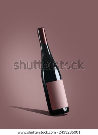 Red wine bottle with label mock up at burgundy background Royalty-Free Stock Photo #2433236001