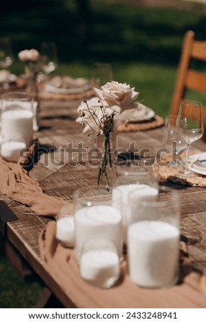 Many small pink and white flower arrangements with roses, eustoma and various flowers in clear glass vases. On the festive table in the wedding banquet area, compositions of flowers and greenery, cand Royalty-Free Stock Photo #2433248941