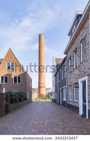 Modern newly build houses surrounding the old towers of the ENKA factory in Ede, Gelderland province in The Netherlands.