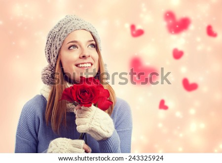 Happy young woman holding red roses with hearts