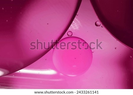 Magenta drops of oil or serum texture background. Oil drops on the water's surface. Macro photography Royalty-Free Stock Photo #2433261141