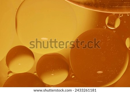 Gold-Yellow drops of oil or serum texture background. Oil drops on the water's surface. Macro photography	 Royalty-Free Stock Photo #2433261181