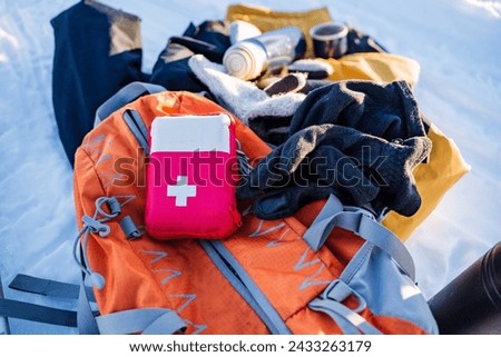 A first aid kit is on a backpack with things, hiking equipment for hiking, survival in the forest. High quality photo