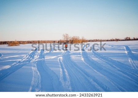 Skier running on skis on snowy field, beautiful winter landscape, outdoor training. High quality photo