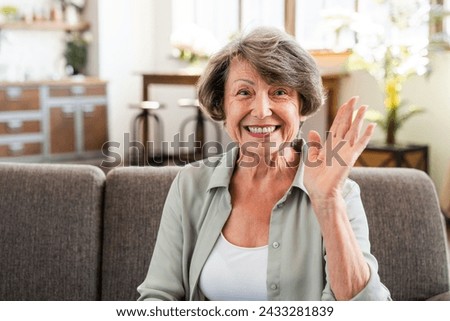 Cheerful caucasian senior woman having videocall online looking at camera and waving with hand. Old grandmother saying hello on webcam while calling Royalty-Free Stock Photo #2433281839