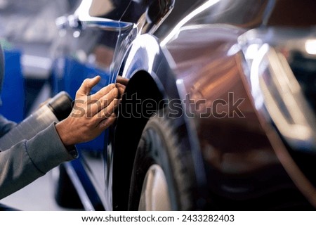 close-up of a car mechanic's hands at a service station applying polishing paste to a car Royalty-Free Stock Photo #2433282403
