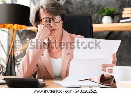 Closeup portrait of caucasian senior old businesswoman ceo manager receiving bad news, report, being fired redundant, paying overdue debt on bills loan banking transaction, mortgage documents Royalty-Free Stock Photo #2433282625