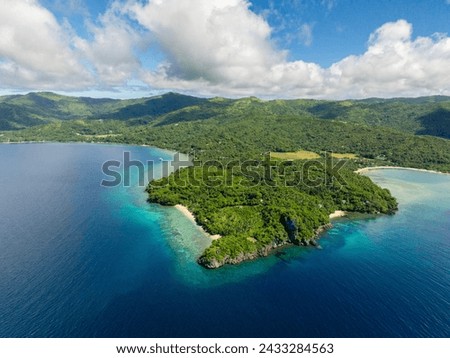 Blue sea and tropical island with green forest. Blue sky and clouds. Romblon Island in Romblon. Philippines.