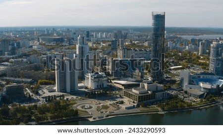 Top view of beautiful modern city with river on sunny day. Stock footage. Beautiful panorama of city with high-rise buildings on sunny summer day. Summer in modern city with skyscrapers and river