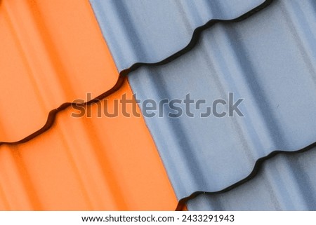 It is photo of light brown and a grey roof tiles. It is a close up view of colorful tiles of roof