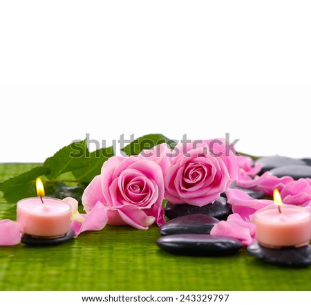 Spa stones with rose flower on green mat
