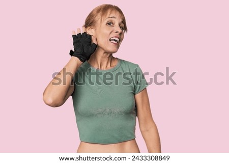 Mid-aged Caucasian athlete with gloves trying to listening a gossip. Royalty-Free Stock Photo #2433308849