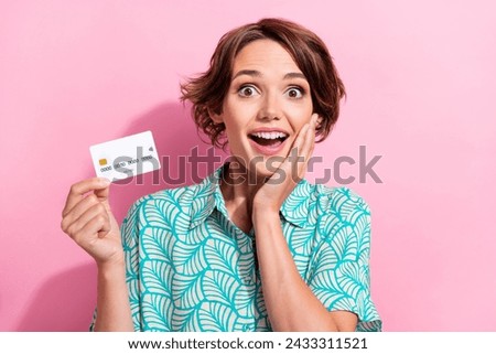 Photo of impressed positive person hand touch cheek hold plastic debit card isolated on pink color background