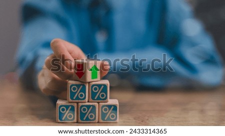 Businessmen flip wooden cubes with percentage icons and up and down arrow icons. Concept of financial interest rates and mortgage rates. Interest Rates Stocks Finance Ratings Mortgage Rates.