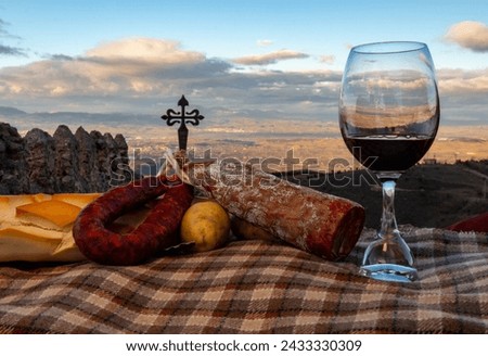 Red wine and spanish red sausage with traditional bread on a castle background
