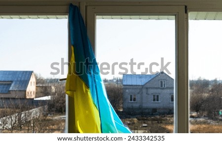 Flag of Ukraine on the window sealed with tape. No war. War in Ukraine