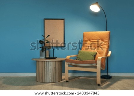 Interior of living room with glowing lamp, armchair and wi-fi router in evening Royalty-Free Stock Photo #2433347845