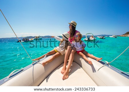 Young mother with her adorable little girls resting on a big boat Royalty-Free Stock Photo #243336733
