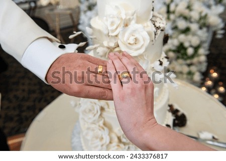 Bride and groom hands wearing gold and diamond rings