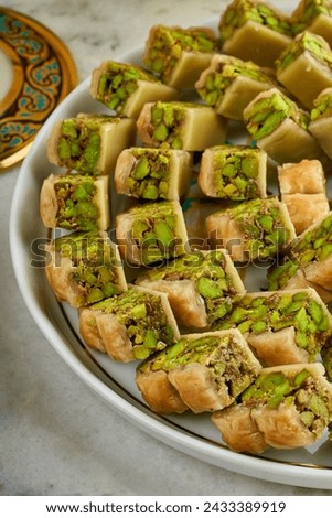 A picture of a plate of Arabic sweets with pistachios, Ramadan sweets