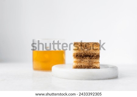 slice of vanilla cake with jam filling on a white plate, thin layers of vanilla and chocolate cake with jam filling on a white background Royalty-Free Stock Photo #2433392305