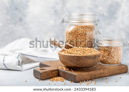 Green buckwheat in a bowl on a wooden kitchen table.Superfood.Raw buckwheat porridge.Healthy vegan food concept, eco products, diet. Copy space.Organic food.weight loss and proper nutrition. Royalty-Free Stock Photo #2433394183