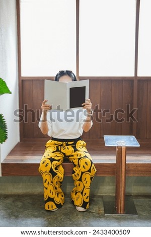 Close up teenage girl holding and reading book or magazine in reading room at home, copy space concept.	
