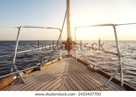 View from yacht's bow sailing towards horizon (skyline) at sunset, serene sunrise scene. Sailing into sunset on open sea, scenery photography. Travel sea cruise concept. Copy ad text space