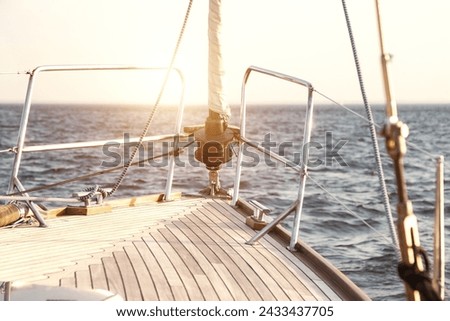 Sailing into sunset on open sea, scenery photography. View from yacht's bow sailing towards horizon (skyline) at sunset, serene sunrise scene. Travel sea cruise concept. Copy ad text space