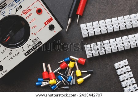Close up several Wire Ferrule and terminal block w wire and Multimeter on top of a black table Royalty-Free Stock Photo #2433442707