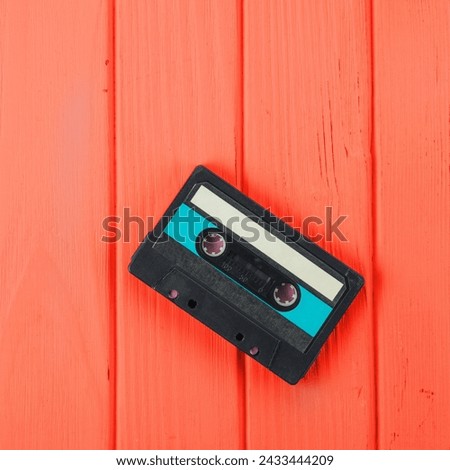 Audio Cassette Tape on Red Wooden Background