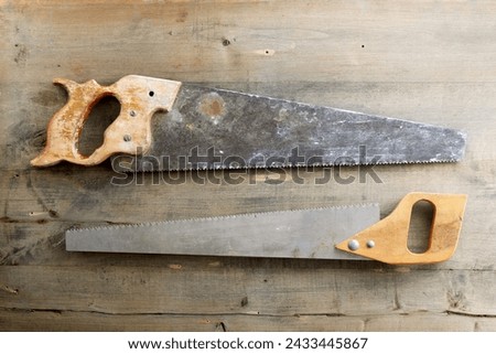 Close up of two disused handsaws on a work bench. Royalty-Free Stock Photo #2433445867