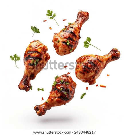 Spicy grilled chicken legs or drumsticks flying with herbs and spices. Floating BBQ chicken drumsticks with vegetables isolated on white background. Royalty-Free Stock Photo #2433448217