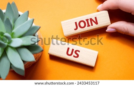 Join us symbol. Concept word Join us on wooden blocks. Beautiful orange background with succulent plant. Businessman hand. Business and Join us concept. Copy space