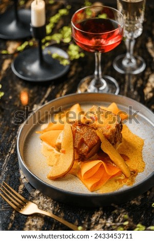 Holiday baked meat with sweet sauce  and pear on marble background with wine glasses, decoration. Holiday healthy food, top view