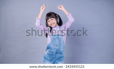 Portrait of young little asian woman relax listen to music sing dance from headphone on back drop.Smile happy asian girl smartphone, technology connection network, lifestyle online education 