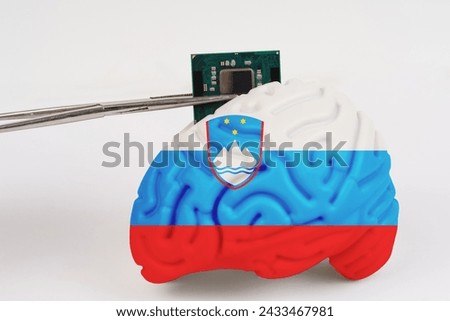 On a white background, a model of the brain with a picture of a flag - Slovenia,a microcircuit, a processor, is implanted into it. Close-up
