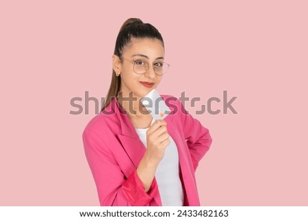 Hold platinum credit card, portrait of attractive young brunette business lady confident beautiful woman hold platinum credit card. Wear formal pink jacket, smiling holding plastic bank card near chin