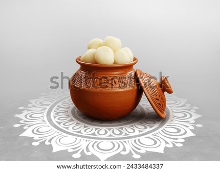 Indian traditional Assorted Sweets Rasgulla on Hari with Alpona Floor Background.