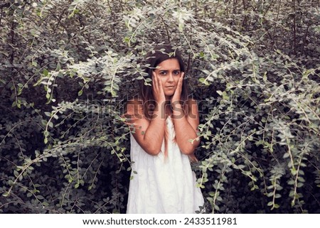 beautiful woman in a white dress, gracefully posed amidst lush green vegetation. 
