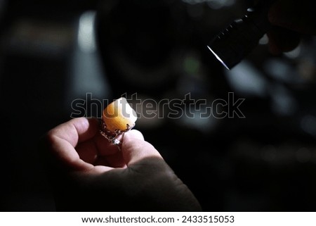 Precious gem stone examination with a flash light. Royalty-Free Stock Photo #2433515053
