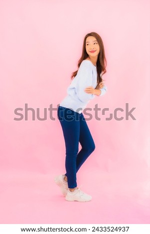 Portrait beautiful young asian woman smile with action on pink isolated background