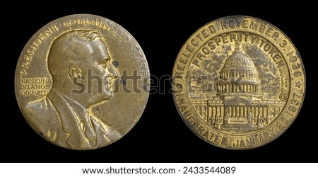 Interesting privately issued metal PROSPERITY TOKEN commemorating 1936 election of FDR and 1937 Inauguration. Profile of Roosevelt on front and U.S. Capitol Building on back. Isolated on black. Royalty-Free Stock Photo #2433544089