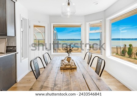 Dining room interior with table and chairs table settings staged with dinnerware flowers large windows bright and spacious home interior photography